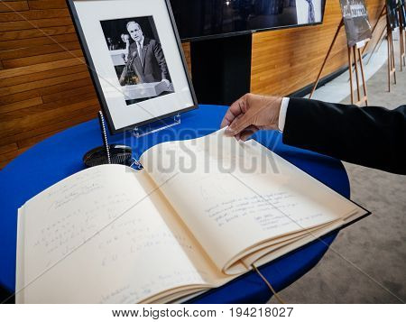 STRASBOURG FRANCE - JUL 1 2017: The messages in diverse languages of high ranked officials on the book of condolences next to a portrait of late former German Chancellor Helmut Kohl at European Parliament. Kohl who was Christ democrat or CDU party member