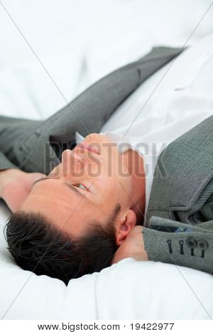 ธุรกิจคนผ่อนคลายขณะนอนอยู่บนเตียงโรงแรม
