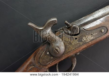 The cocked trigger of a flintlock part of old-fashioned gun