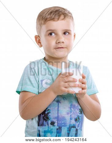 Close-up charming boy with milk. Beautiful little kid with pretty smile is holding a glass of fresh and organic milk isolated on a white background.