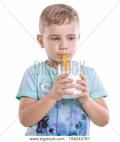 A cute little kid in blue t-shirt with a glass full of nutritious and organic milk isolated on a white background. Pretty little boy is drinking milk from a yelllow straw isolated on a white background.