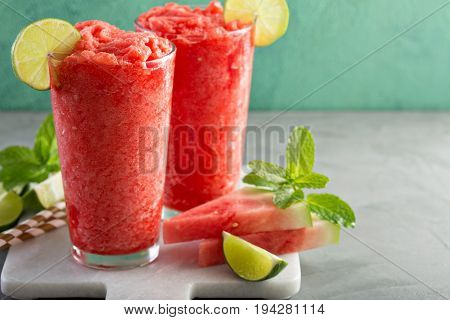 Watermelon slushie with lime, summer refreshing drink in tall glasses