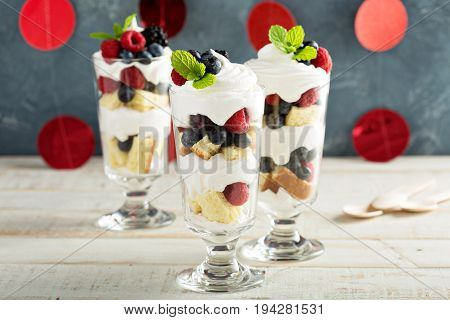 Layered dessert parfait with sweet bread, whipped cream and berries