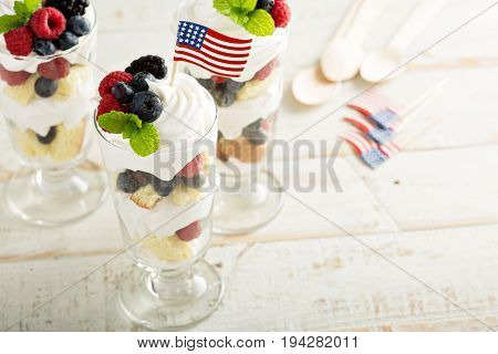 Layered dessert parfait with sweet bread, whipped cream and berries for 4th of July
