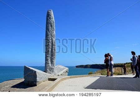POINTE DU HOC FRANCE - AUG 12: Visitors look at the Ranger Monument at Pointe Du Hoc France on August 12 2016. The Monument sits atop a German observation bunker.