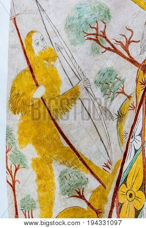 Hunter with bow and arrow dressd in a fur-coat a medieval fresco in Vinderslev church Denmark June 22 2017