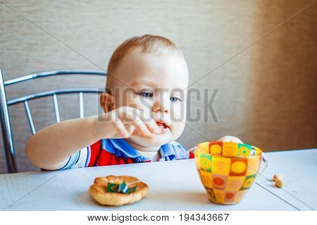 Little boy is sitting at the kitchen table