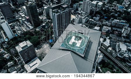 Aerial drone top view of helipad isolated on top of the skycraper in Bangkok city 