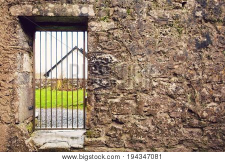 Locked gate in old stone wall