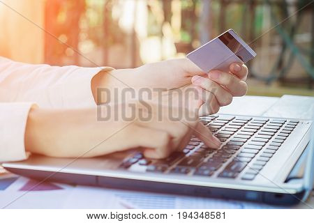 Woman's Hands Holding A Credit Card And Using Smart Phone For Online Shopping.vintage Tone