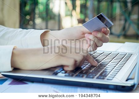 Woman's Hands Holding A Credit Card And Using Smart Phone For Online Shopping.vintage Tone