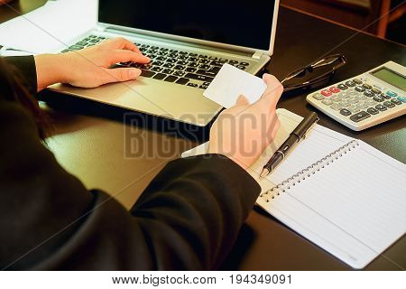 Woman's Hands Holding A Credit Card And Using Smart Phone For Online Shopping.vintage Tone