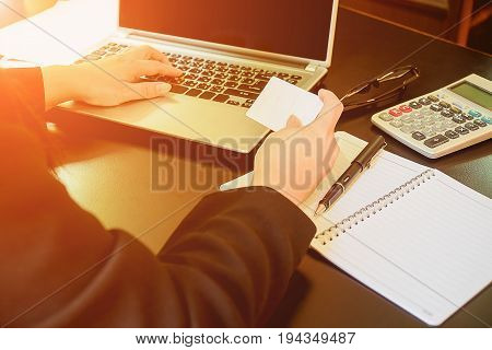 Woman's Hands Holding A Credit Card And Using Smart Phone For Online Shopping.vintage Tone