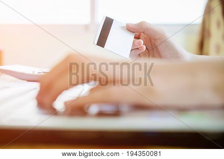 Woman's Hands Holding A Credit Card And Using Smart Phone For Online Shopping.vintage Tone