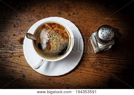 a cup of coffee on an old wooden table