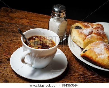 a cup of coffee and cakes on old wooden table - breakfast