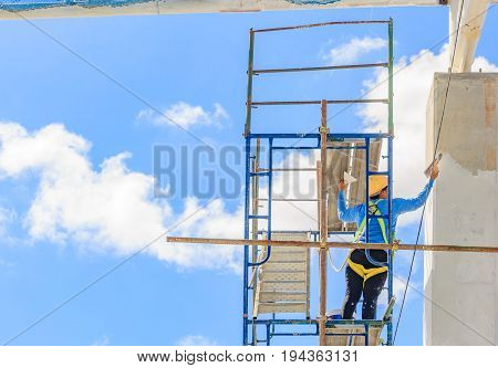 Construction workers working on scaffolding Women working on the Working at height with blue sky at construction site labor protection