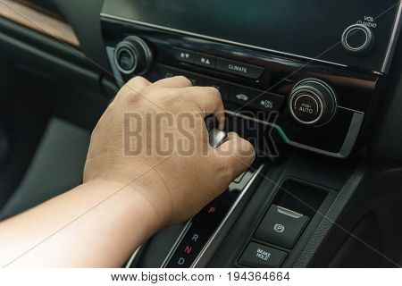hand on automatic gear shift Man hand shifting an automatic car luxury car design interior
