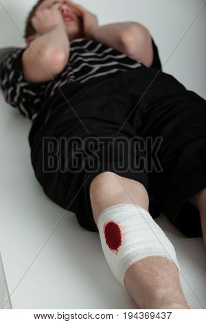 Crying Boy Laying Down With Injured Leg