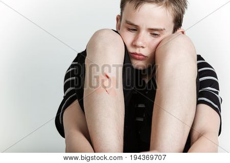 Sad Boy Sitting With Injured Shin