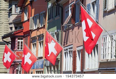 Ancient street Augustinergasse in Zurich decorated with swiss flags