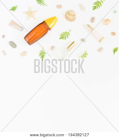 Cosmetics summer background. Cosmetics SPA makeup tubes bottles sea pebbles and shells on white background. Flat lay top view.