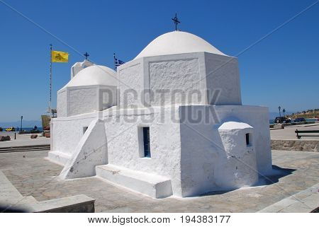AEGINA, GREECE - APRIL 26, 2017: The whitewashed church of Agios Nikolaos on the harbour front at Aegina Town on the Greek island of Aegina. The island is a popular destination for Athenians.