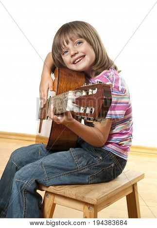 a little girl is playing a guitar