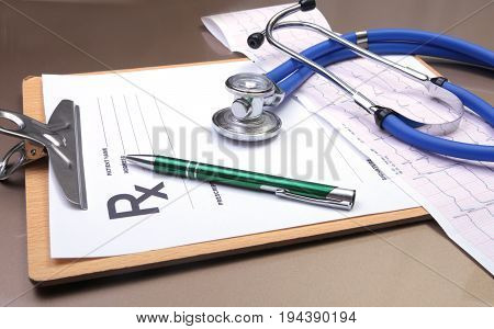 RX prescription, Red heart, asorted pils and a stethoscope on white background.