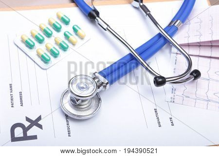 RX prescription, Red heart, asorted pils and a stethoscope on white background.