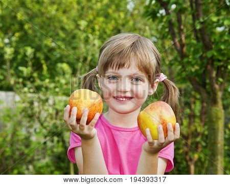 little girl with apples in the garden