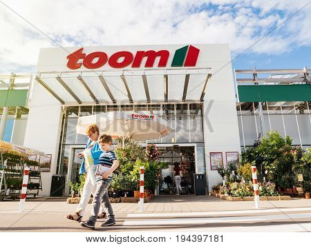 FRANKFURT GERMANY - JUN 30 2017: Mother and child walking to the entrance of TOOM the German DIY-store chain offering home improvement and do-it-yourself goods - customers buying goods selecting the best tools