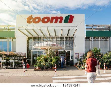 FRANKFURT GERMANY - JUN 30 2017: Woman walking to the entrance of TOOM Baumarkt the German DIY-store chain offering home improvement and do-it-yourself goods - customers buying goods selecting the best tools