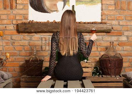 Woman Tasting Wine In Rural Cottage Interior