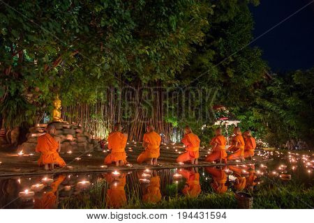 CHIANG MAI THAILAND - JULY 08 2017 :Unidentified monks in ritual around Buddha statue among many candlelight at Phan Tao temple Chiang maiThailand in Asanha Puja Day