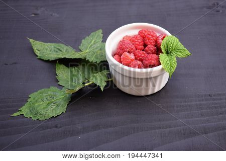 Ripe and tasty raspberries on a wooden background. Raspberries on wooden table .Fresh , vitamins healthy food vegan ingredients.