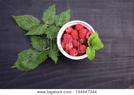 Ripe and tasty raspberries on a wooden background. Raspberries on wooden table .Fresh , vitamins healthy food vegan ingredients.