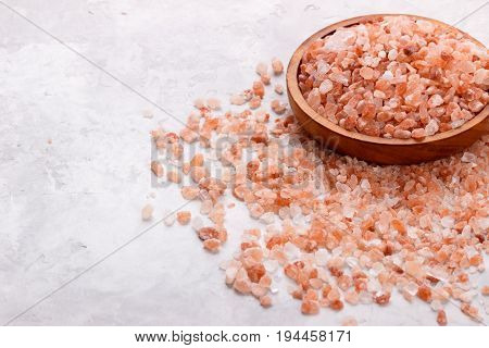 Pink himalayan salt over white stone background, close up top view with space for text