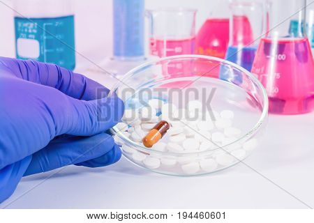 Scientist analyzing pills in medical laboratory. Analysis of medicaments in laboratory. Medical Research and diseases Science.