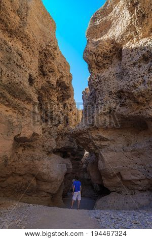 Man At Sesriem Canyon Near Sossusvlei. Shaped By Tsauchab River, Namib Desert, Namibia