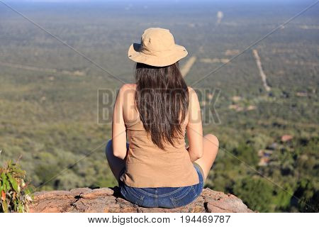 Girl Sitting On Stone On The Cliff At An Forest Landscape.