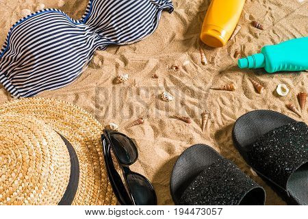 Summer bikini and accessories stylish beach set, Beach bikini summer outfit and sea sand as background, Top View, Concept. Copy space