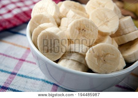 Slices of fresh bananas in a bowl close up
