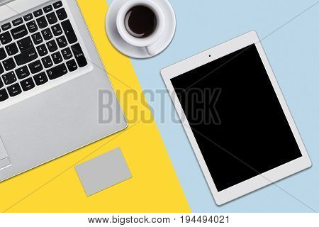 Modern workplace. Top view of laptop computer tablet cup of cofffe or tea on flat surface. Computer and tablet on office desk. Computer elecronic devices. Social network user modern equipment