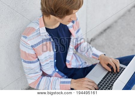 Cropped Shot Of Stylish Male Student Working At His Course Paper Typing At Laptop Computer Necessary