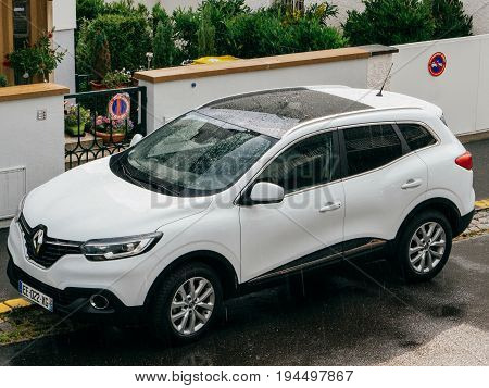 STRASBOURG FRANCE - MAY 30 2016: Rain drops over aerial view of a white Renault Kadjar SUV car parked near a beautiful house. Renault is the bigest French automobile maker