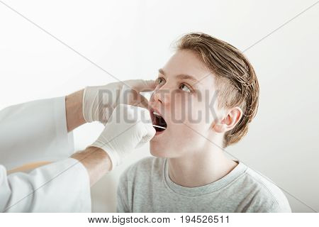 Teenage Boy Having Mouth Examined By Doctor