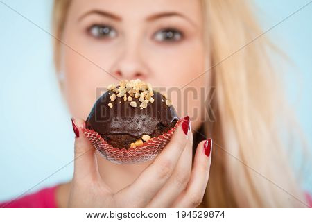 Woman Holding Chocolate Cupcake About To Bite