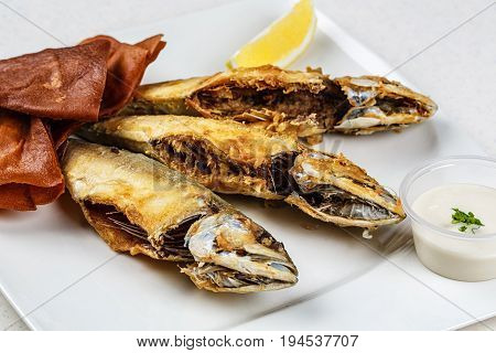 Tasty fish with vegetables and lemon on kitchen table
