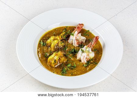 Prawn curry served with parsley on white plate